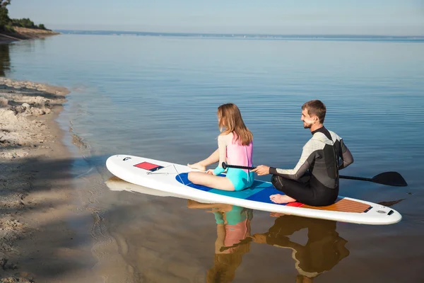 Young couple paddling on sup board — Stock Photo, Image