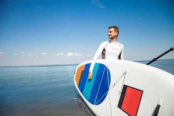 Молодой человек с веслом на пляже — стоковое фото