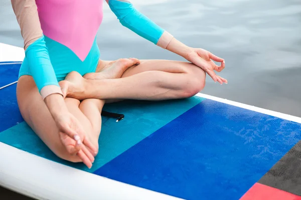 Kvinnan gör yoga sup ombord med paddel — Stockfoto