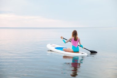 SUP tahta kürek çekmeye tanınmaz halde genç kadın