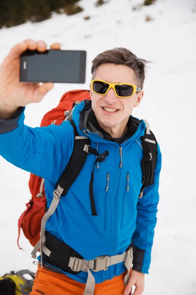 Turysta w górach zimą co selfie na smartphone — Zdjęcie stockowe