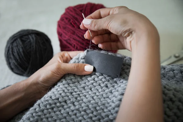 Woman sewing the genuine leather lable