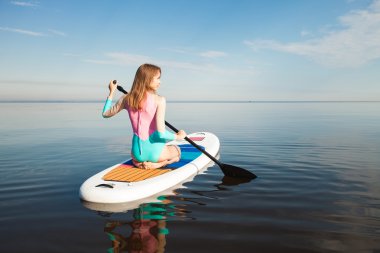 Genç kadın SUP tahta kürek çekmeye 