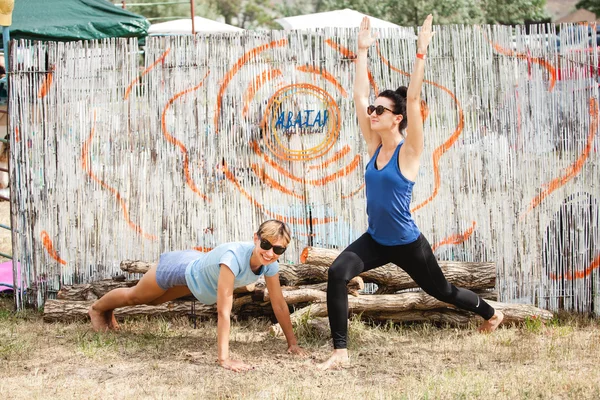 Dos mujeres contra fondo con logo de Avatar Yoga Festival — Foto de Stock