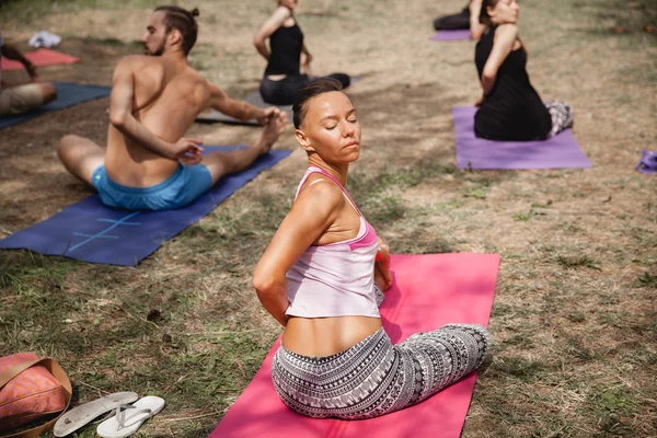 Gente haciendo twist en la práctica al aire libre durante el Avatar Yoga Festival — Foto de Stock