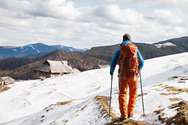 Hiker in winter mountains passing out from camera
