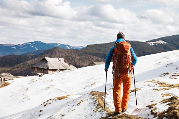Турист в зимних горах, теряющий сознание от камеры — стоковое фото
