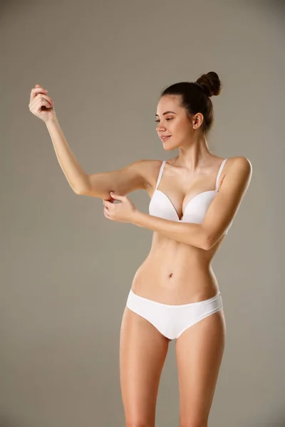 Mujer pellizcando la piel en su mano comprobando la capa de grasa corporal subcutánea — Foto de Stock