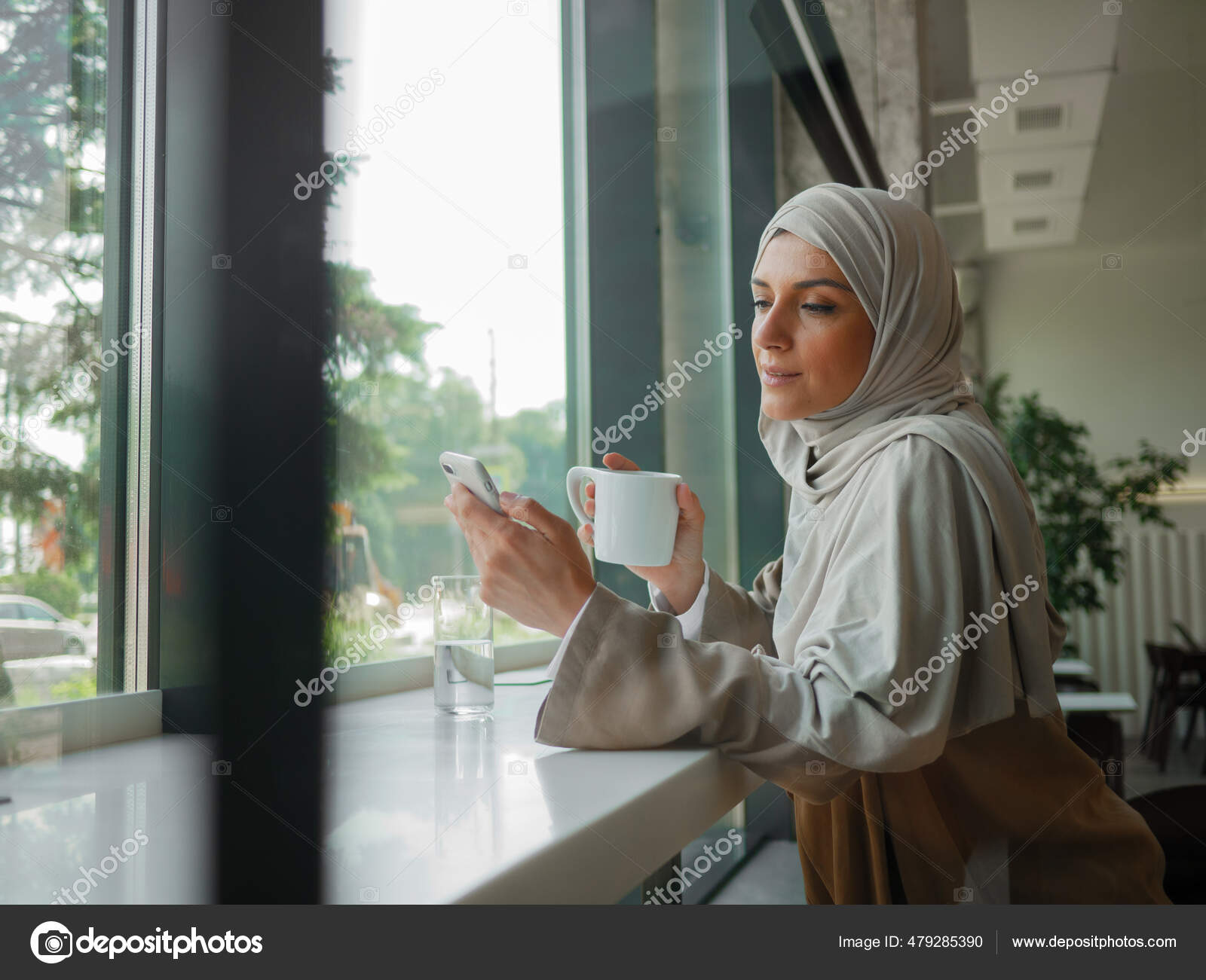 Muslim woman on remote working, online education or video conversation in caffe Stock Photo by
