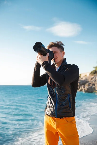 Мужчина-турист с фотокамерой на рассвете — стоковое фото
