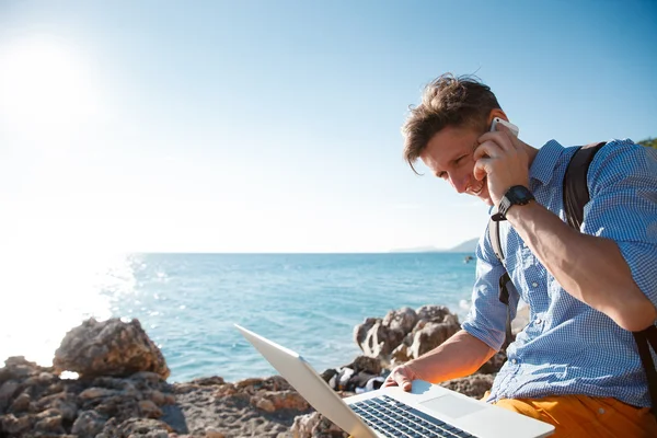 Freelance sur l'ordinateur portable au bord de la mer — Photo