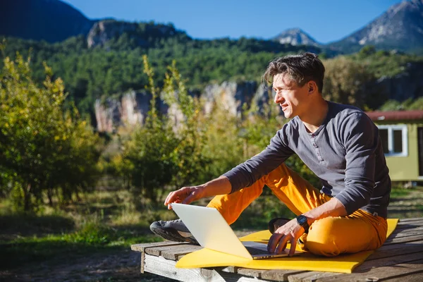 Freelancer pracuje na komputerze przez krajobraz górski — Zdjęcie stockowe