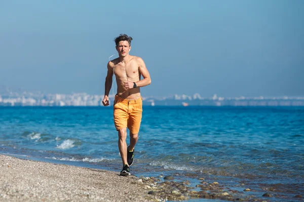 Hombre corriendo al amanecer en el agua — Foto de Stock