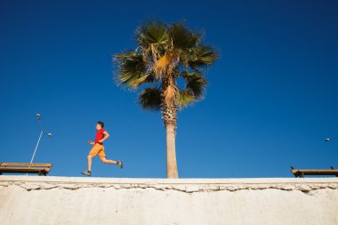 Üzerinde mavi gökyüzü koşan adam