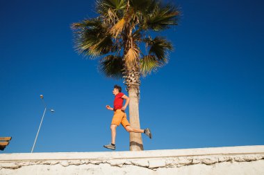 Üzerinde mavi gökyüzü koşan adam