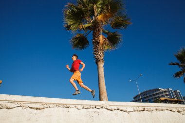 Üzerinde mavi gökyüzü koşan adam