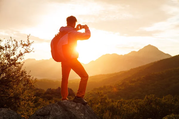 Hiker stands on the cliff over the sunrise — Stock Photo, Image