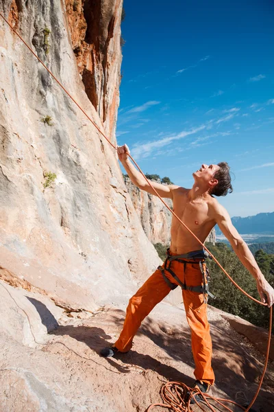 Rock climber holding belay rope over the mountains — Stock Photo, Image