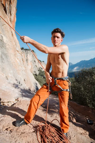 Bergsteiger sammelt Sicherungsseil über den Bergen ein — Stockfoto