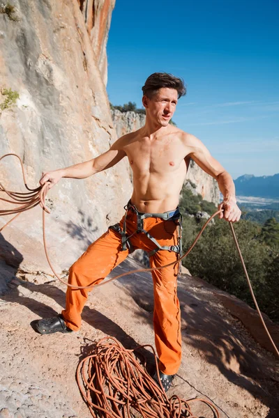 Bergsteiger sammelt Sicherungsseil über den Bergen ein — Stockfoto