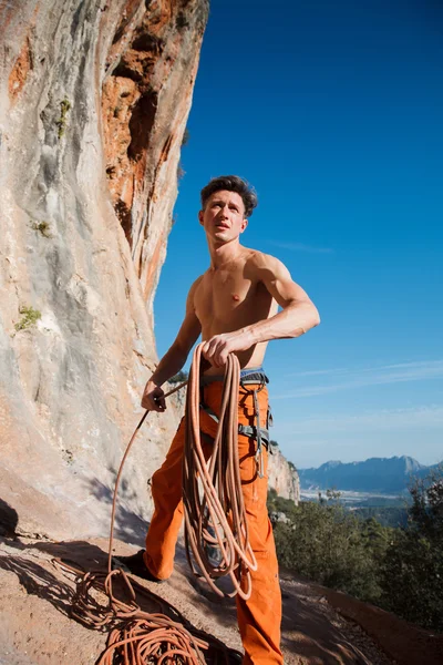 Escalador de roca recogiendo la cuerda de abajo sobre las montañas — Foto de Stock
