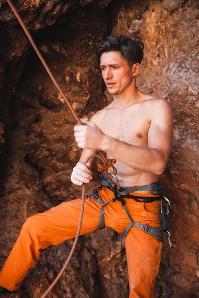 Bergsteiger hält Sicherungsseil gegen Felsen — Stockfoto