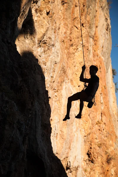 Silhouette of rock climber hanging on belay rope againstthe mountains — Stock Photo, Image