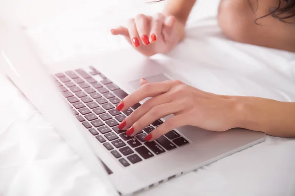 Mujer manos con ordenador portátil en la cama —  Fotos de Stock