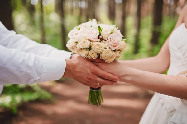 The bride and groom are holding a bouquet — Stock Photo, Image