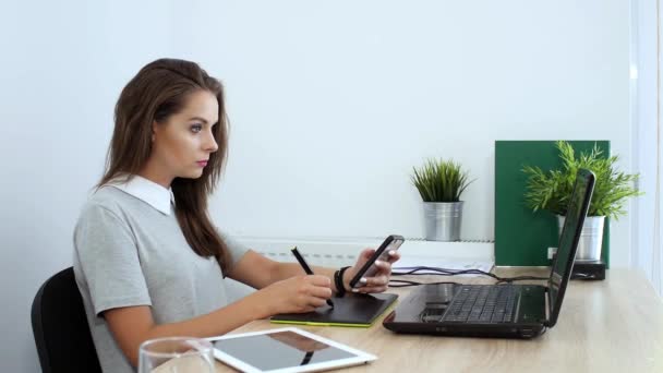 Femme d'affaires réécriture message du smartphone à l'ordinateur portable — Video