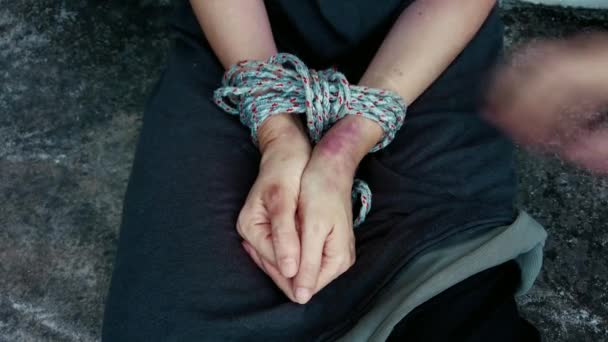Mãos atadas com hematomas de uma mulher sentada no chão. Conceito de violência doméstica. Abuso de uma mulher, tráfico de pessoas — Vídeo de Stock