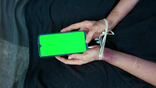 Концепция насилия в социальных сетях в отношении человека. Смартфон Nomophobia использует психопатологию образа жизни. Руки с синяками женщины, сидящей на полу. — стоковое видео