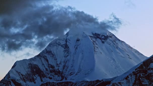 Az éjszaka kezdetének időpontja egy havas csúcson. felhők kavarognak a Nilgiri hegy csúcsa felett. — Stock videók