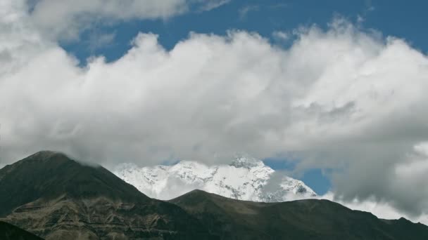 Nad horským údolím víří mračna, v dálce zasněžený vrchol. Mustang, Nepál, Annapurna — Stock video