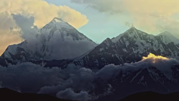Zeitraffer des Anbruchs der Nacht auf einem verschneiten Gipfel. Wolken wirbeln über den Gipfel des Mount Nilgiri — Stockvideo
