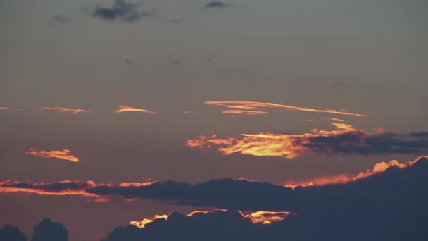 Disque lumineux du soleil se déplace à travers des bandes de nuages dans le ciel brillant de coucher de soleil — Video