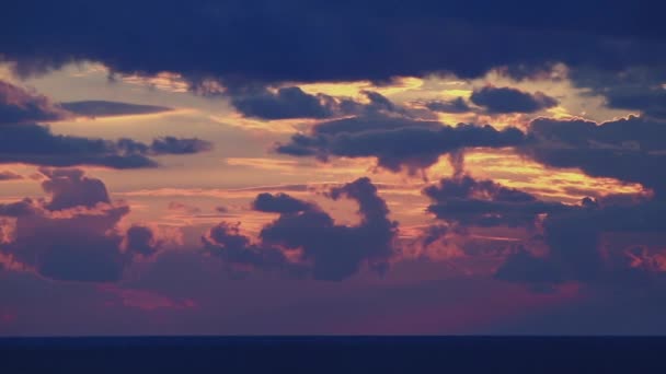 Brillante disco de sol se mueve a través de las aberturas de nubes en el cielo brillante puesta de sol — Vídeo de stock