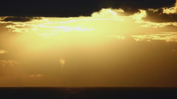 Brillante disco de sol se mueve a través de las aberturas de nubes en el cielo brillante puesta de sol — Vídeos de Stock