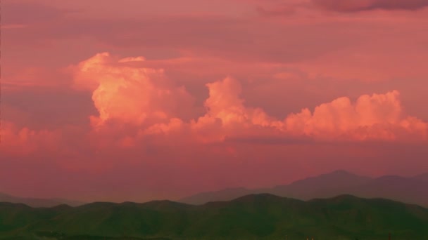 Timelapse. O movimento de nuvens cor-de-rosa no céu em campos e colinas intermináveis Fundo para a montagem Fundo para o conceito de grandes sonhos, esperanças e aspirações. — Vídeo de Stock