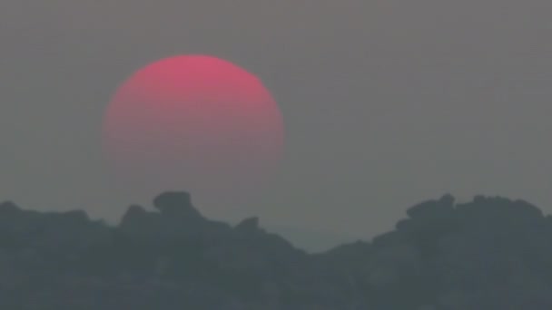 Timelapse, un grand soleil se couche dans des nuages orange qui deviennent bleus. — Video