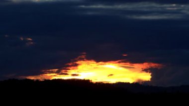 Gün batımında güzel, karanlık bir zemin, bulutlar pürüzsüz ve hızlı uçar Yavaş çekim statik kamera