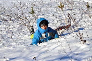 Kış çocuk oyunları, güneşli bir günde kızakla kayma. Şehir parkında ya da kırsal kesimde kış çocuk eğlencesi..