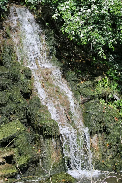 Водопад над камнями в пруд — стоковое фото