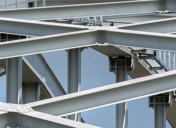 The steel structure of a railway bridge with steel beams and columns and an arch