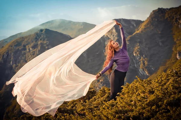 Menina brincando com o vento nas montanhas — Fotografia de Stock