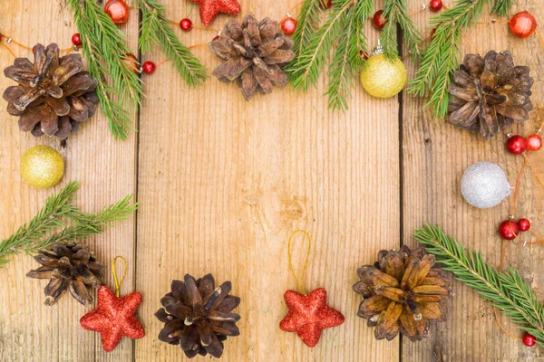 Decoración navideña sobre escritorio rústico de madera (conos de pino, canela, anís, ramas de abeto, estrellas rojas ) — Foto de Stock