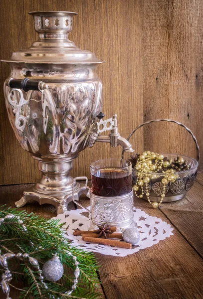 Čaj ve skle s dráha a ruský samovar na dřevěné pozadí. Domácí Vánoční dekorace — Stock fotografie