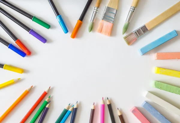 Yuvarlak çerçeve, Boya fırçaları, keçeli kalemler, cholks, yapılan kalem beyaz arka plan üzerinde renkli 
