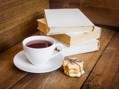 Kitaplar, kurabiye ve çay ahşap arka plan üzerinde