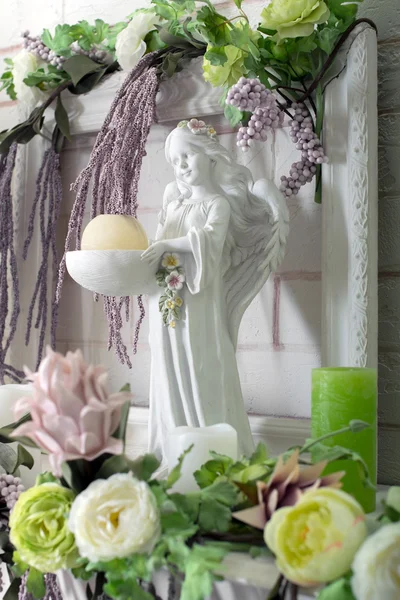 angel figurine in flowers with candle